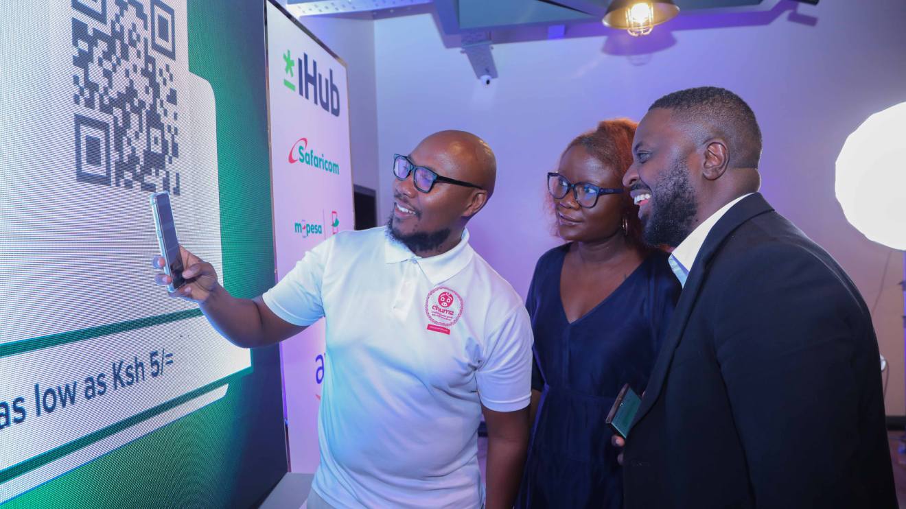 Chumz CEO Samuel Njuguna scans the Chumz QR code to show how the application runs to Mpesa Africa Chief Commercial Officer, Felix Kamenga (c) and Safaricom PLC Brand and Marketing Director Zizwe Awuor. PHOTO/COURTESY